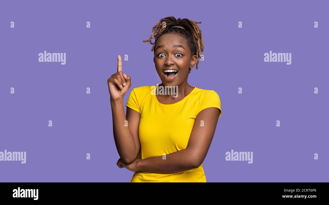 Inspired black female pointing finger up, got idea Stock Photo