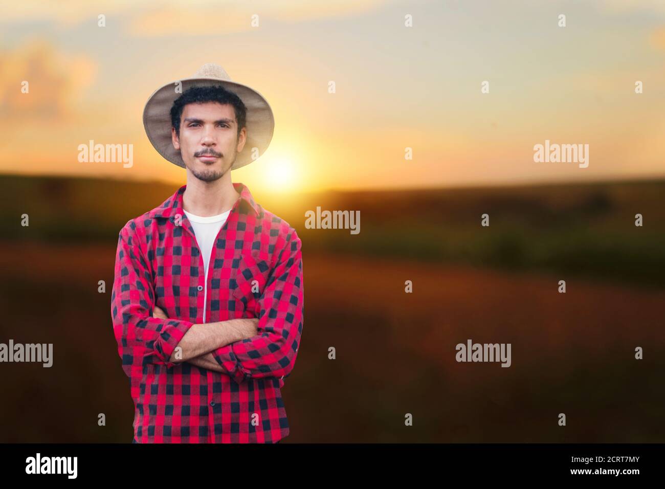 Farmer at sunset outdoor . Man with hat in a sunset blurry background. Space for text. Stock Photo