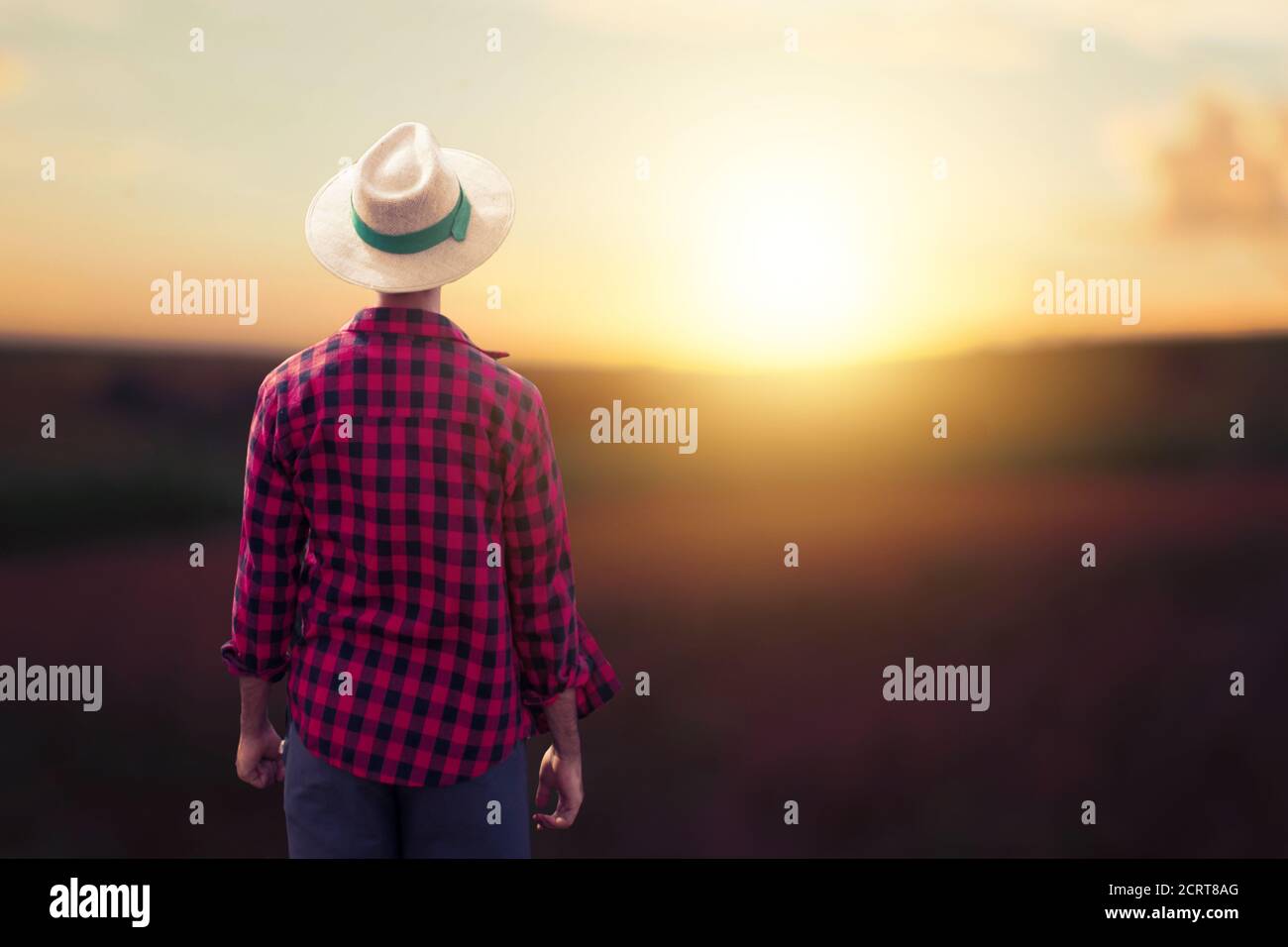 Farmer at sunset outdoor . Man with hat in a sunset blurry background. Space for text. Stock Photo