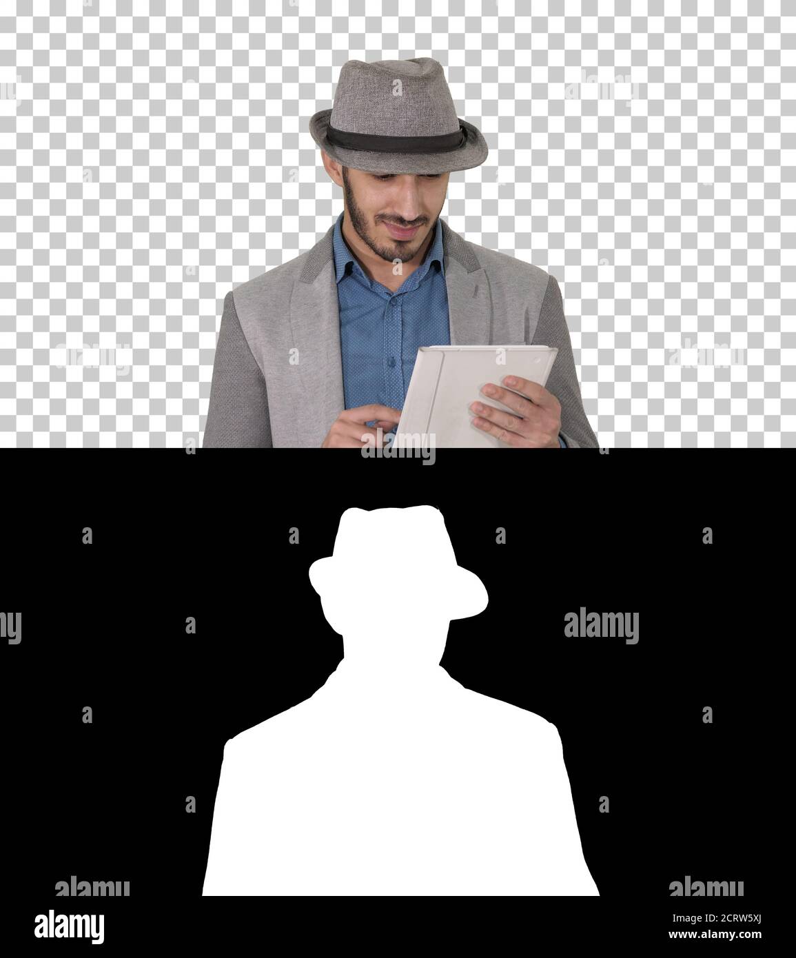 Handsome smiling arab man in a hat walking and using tablet, Alp Stock Photo