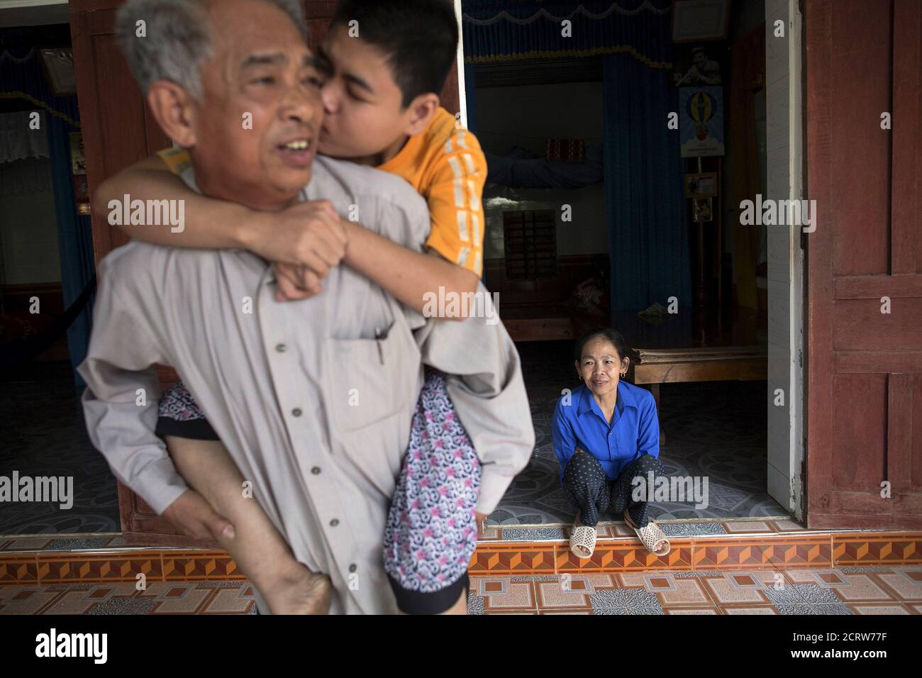 A Former Soldier Do Duc Diu Is Kissed By His Disabled Daughter Do Thi Nga As His Wife Sits At The Doorway Of Their House In Quang Binh Province In Central Vietnam A Former Soldier Do Duc Diu Is Kissed By His Disabled Daughter Do Thi Nga As His Wife Sits At The Doorway Of Their House In Quang Binh Province In Central Vietnam