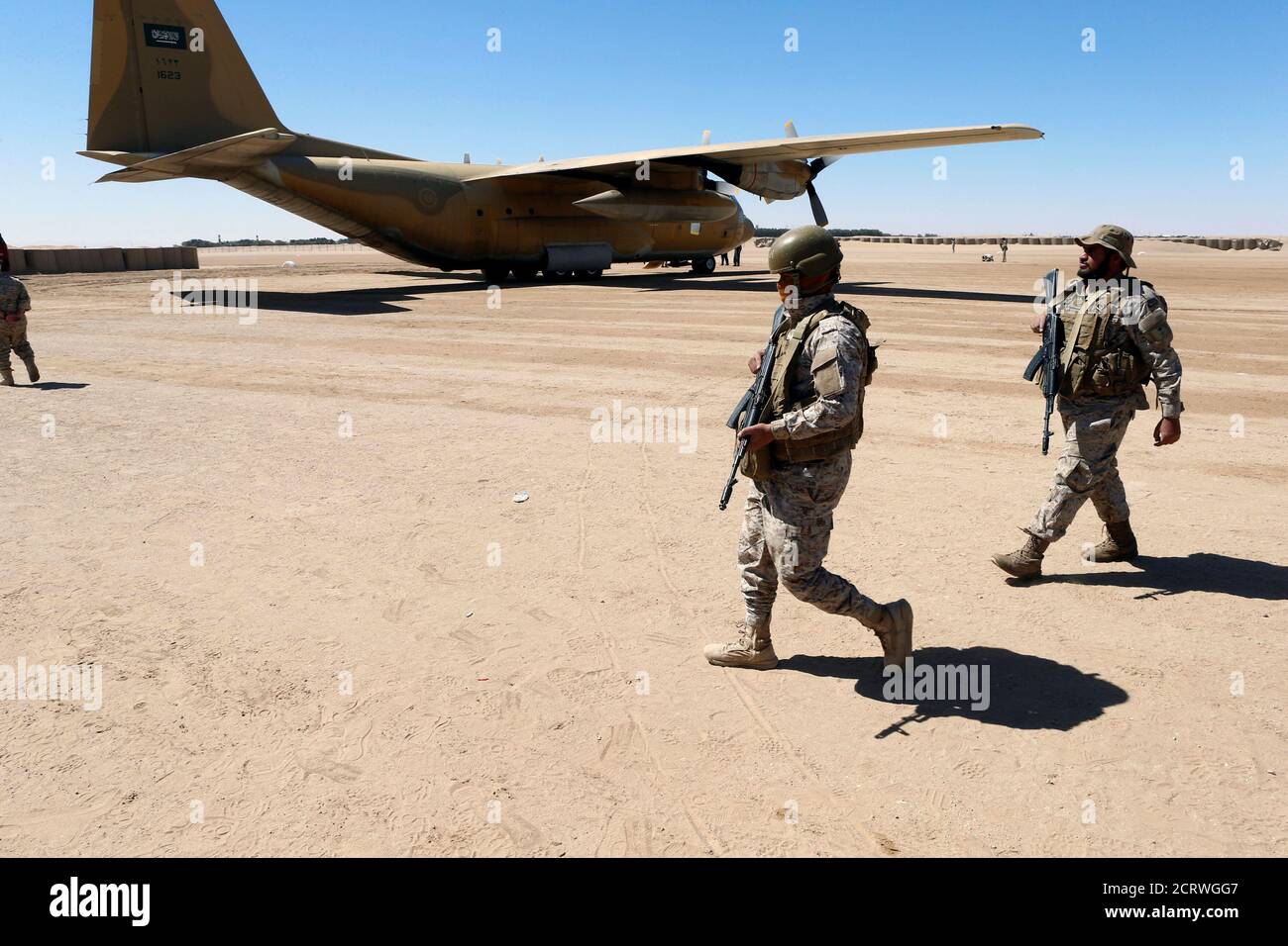 Saudi soldiers walk at an airfield where Saudi military cargo planes land to deliver aid in Marib, Yemen January 26, 2018. Picture taken January 26, 2018. REUTERS/Faisal Al Nasser Stock Photo