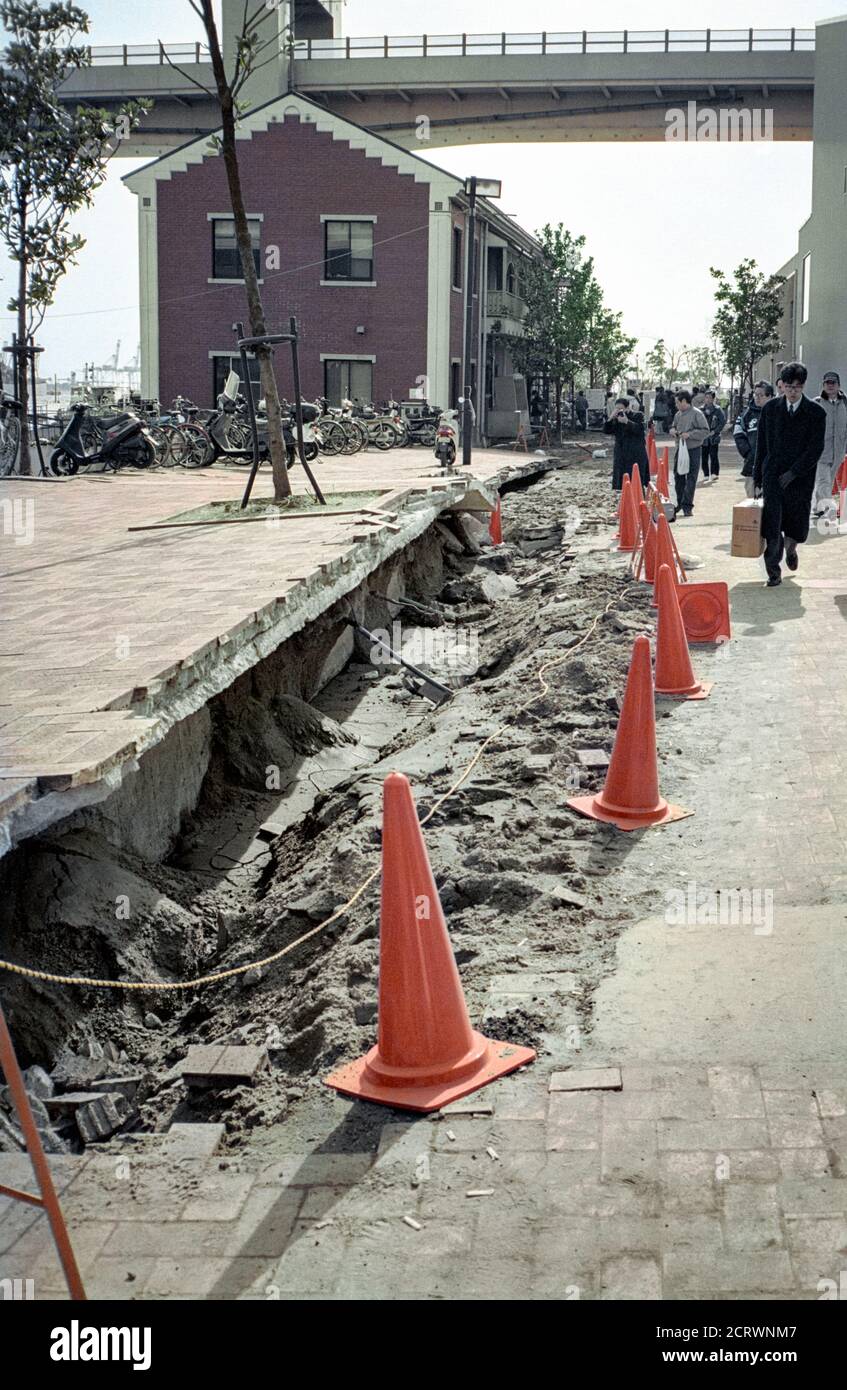 Commuters walk past a rift in the pavement showing the damage caused by the 1995 Great Hanshin Earthquake in Kobe, Japan Stock Photo