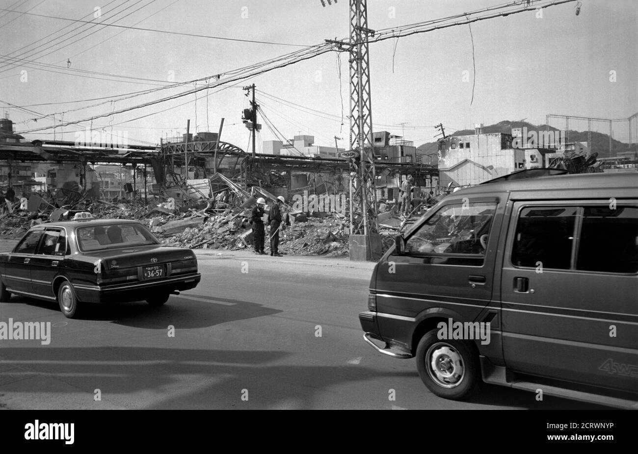 Taxi and van drives past ruins in the aftermath of the 1995 Great Hanshin Earthquake in Kobe, Japan Stock Photo