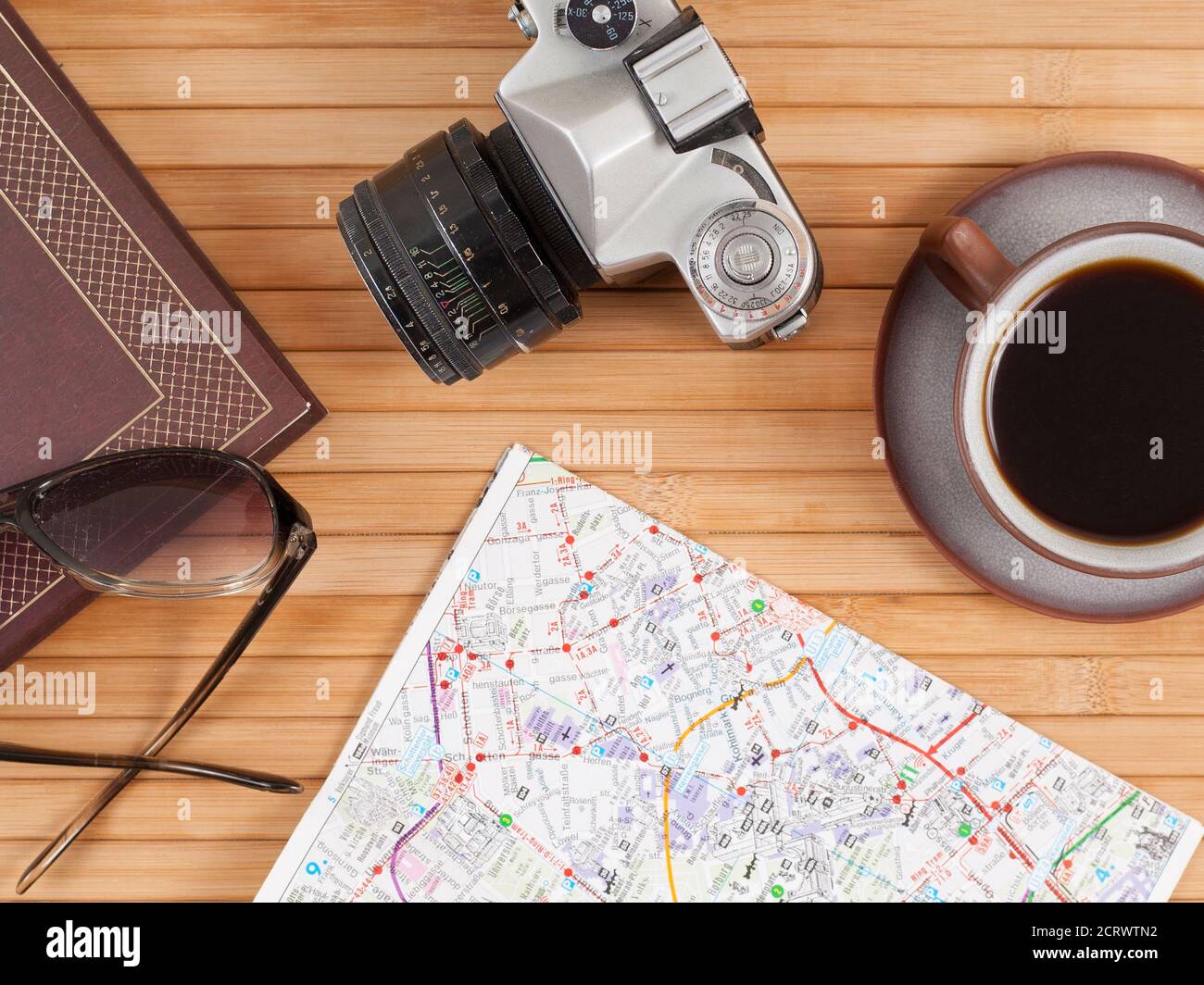 Travel preparations essentials world map cup of coffee vintage film camera notebook Stock Photo