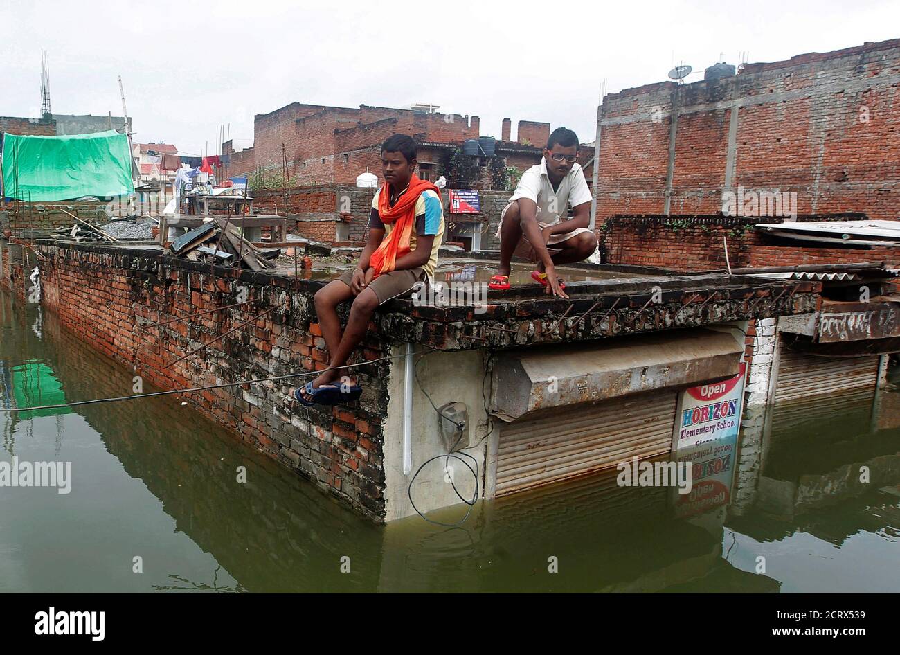 Man sitting on roof flood hi-res stock photography and images - Alamy
