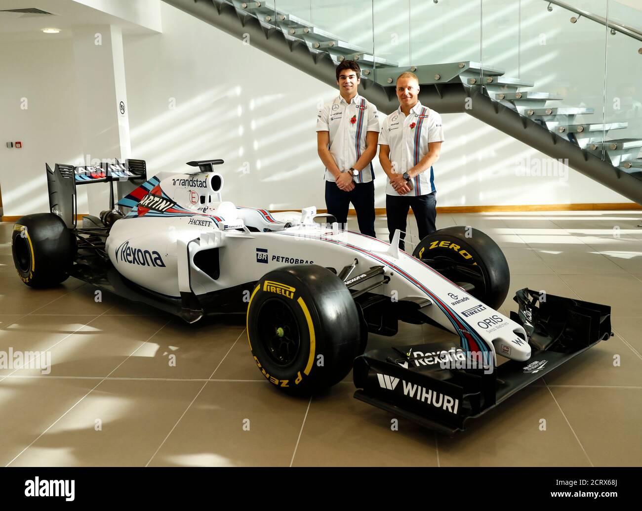 The newly announced Williams Martini Racing driver for the 2017 season  Lance Stroll (L) poses for photographers with team-mate Valteri Bottas  beside this year's Formula 1 car at their base in Wantage,