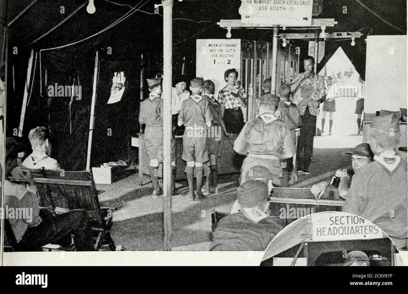 . Bell telephone magazine . o • vi :^!i ^..  ^i K * , Nearly a hundred operators and super-visory personnel were on hand to attendthe six-position switchboard (above),the locator center in the telephonebuilding (belozv), and the public tele-phone centers. Camp life for the girlsincluded doing their own laundry -«^. kS^I A^ J )>^X- .m k. kt^ ^b^ ^ try. Fhi public telephone tents zvere spacedthroughout the encampment. Traffic andCommercial attendants were on duty till liP. M., and Scouts used the facilities to makelong distance calls home as well as to locaterelatives and friends in Souther Stock Photo
