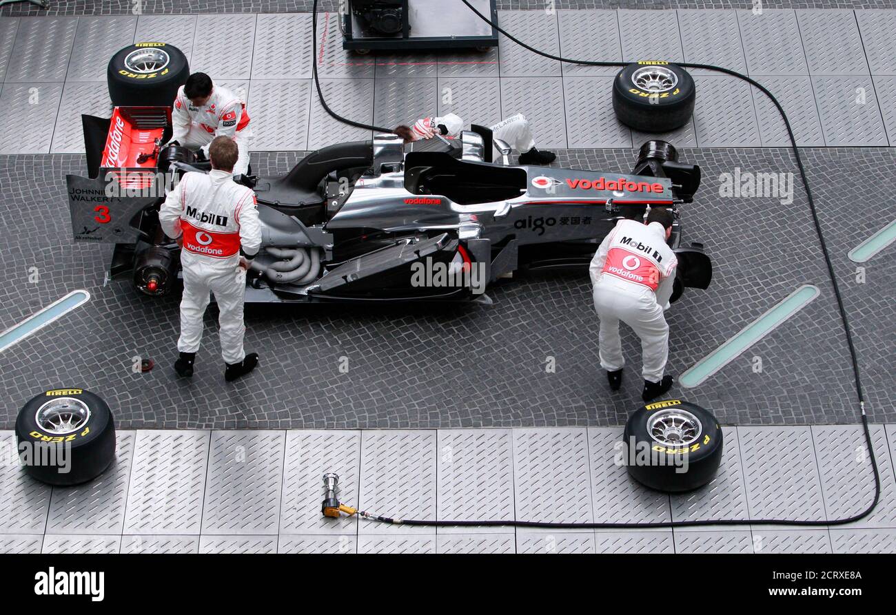 Mechanics assemble the new Formula One McLaren Mercedes MP4-26 racing car during its unveiling ceremony in Berlin, February 4, 2011.  REUTERS/Thomas Peter  (GERMANY - Tags: SPORT MOTOR RACING) Stock Photo
