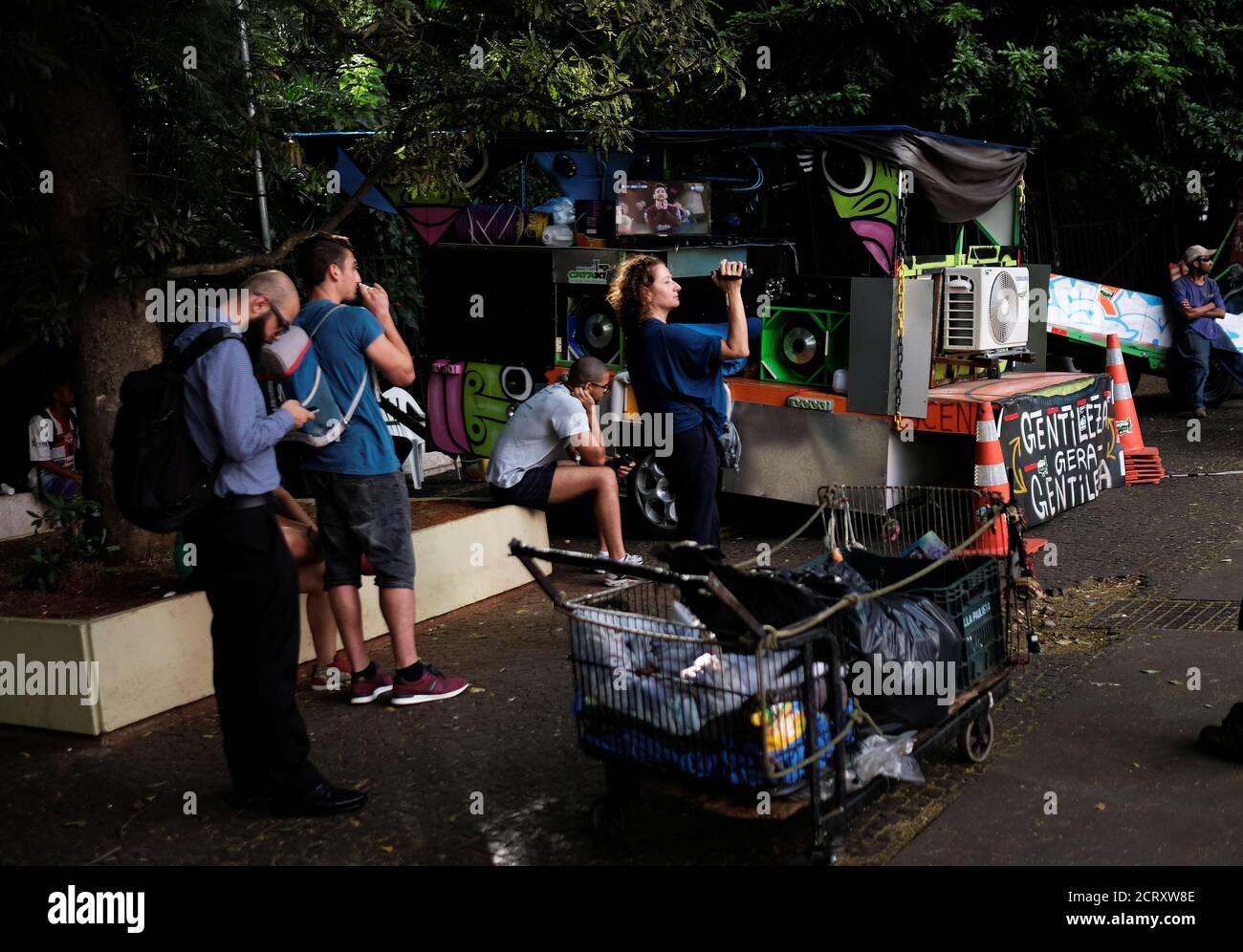 People watch Barcelona's Lionel Messi gesture against Chelsea on the TV of Lucena (not pictured) who recycles used materials on his cart in Sao Paulo, Brazil, February 20, 2018. REUTERS/Nacho Doce Stock Photo