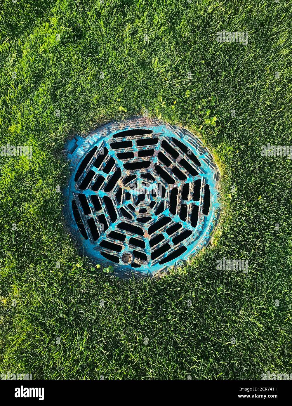 Blue water drain hatch on golf course with grass background Stock Photo