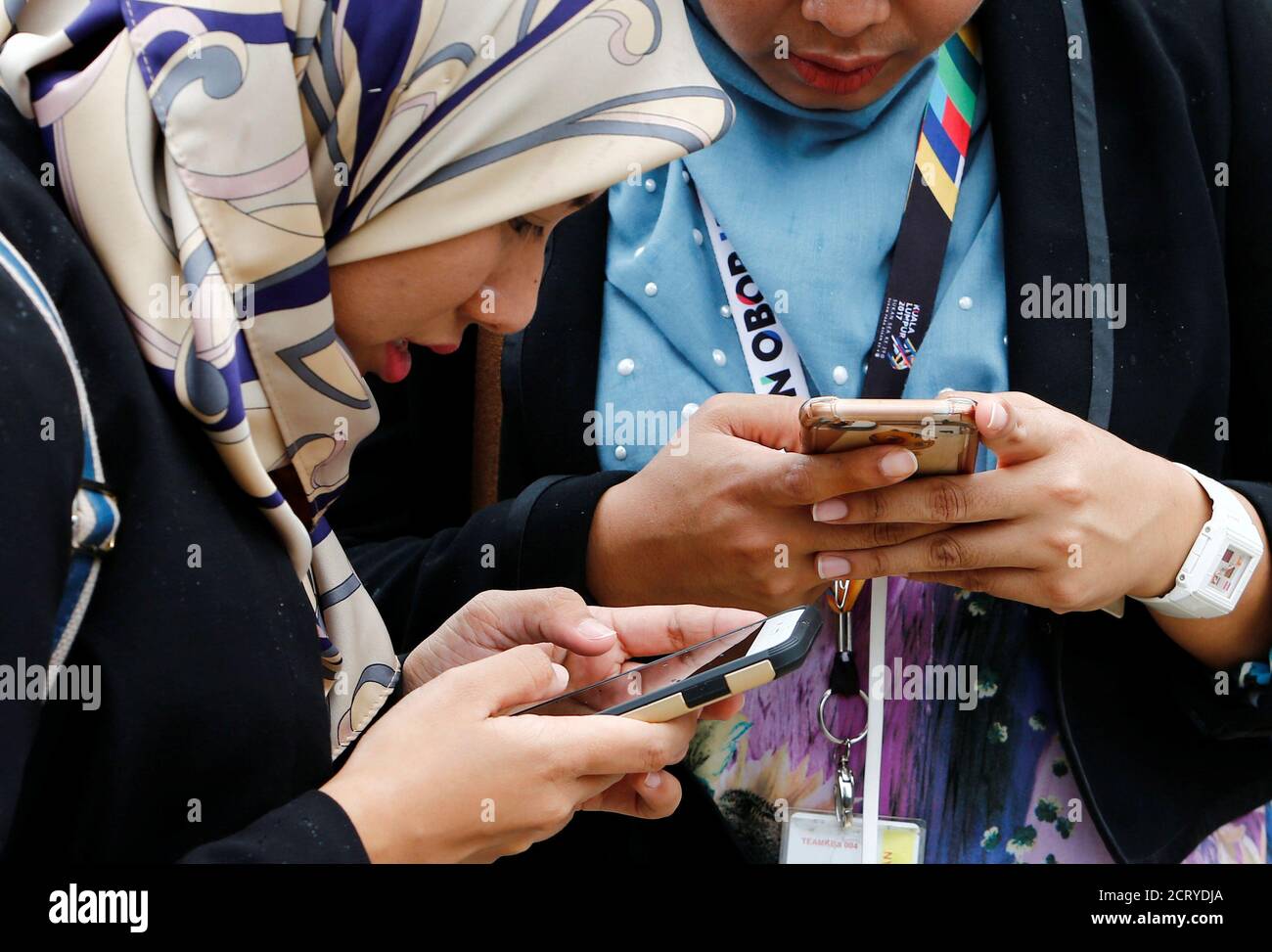 Women use their mobile phones at a university in Semenyih, outside Kuala Lumpur, Malaysia November 3, 2017. REUTERS/Lai Seng Sin Stock Photo