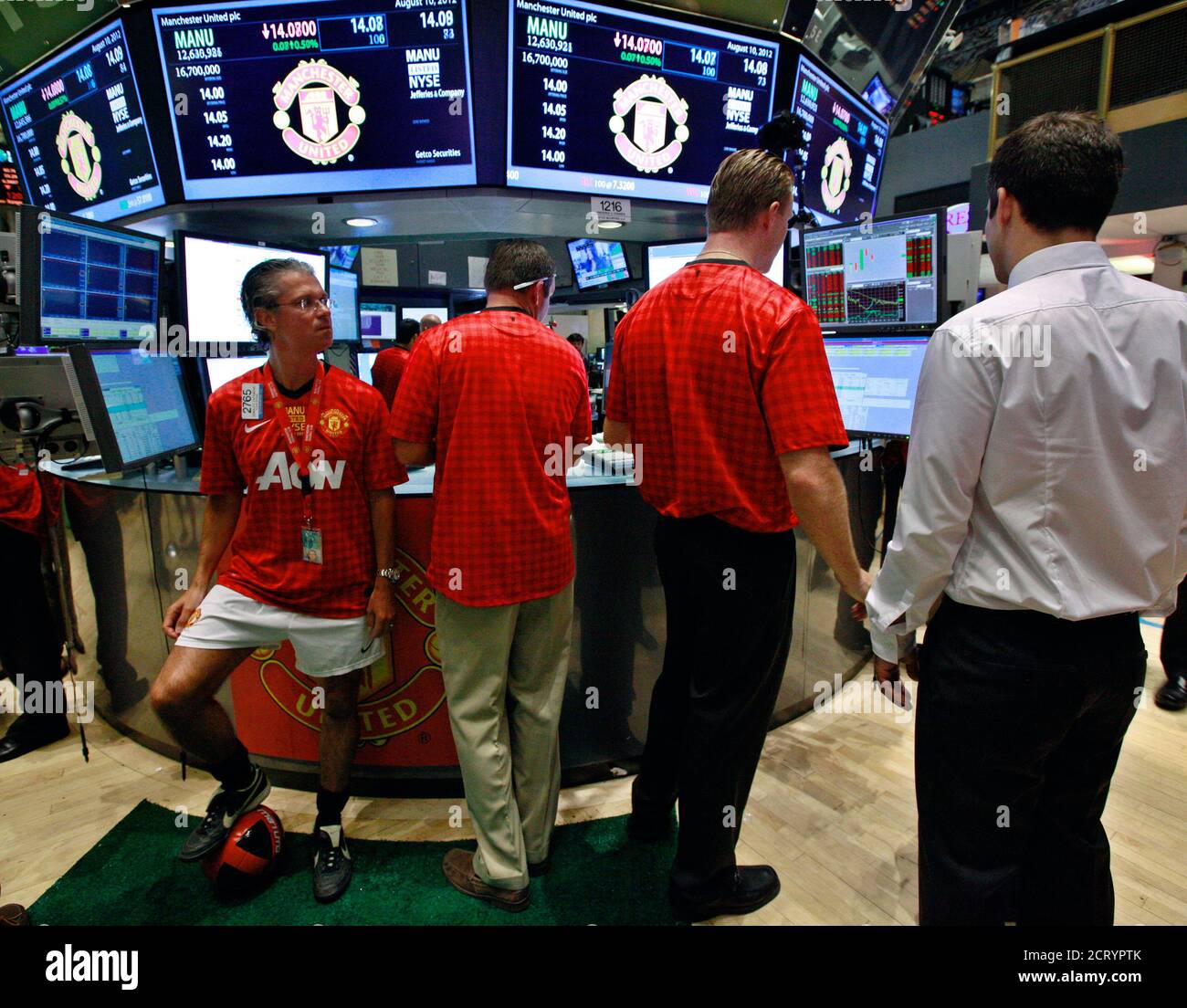 Traders from Getco Securities work at the post that trades Manchester United Ltd following its initial public offering on the floor of the New York Stock Exchange, August 10, 2012. Shares in Manchester United priced below expectations and were essentially flat in early trading on Friday, a disappointing stock market debut for the world's most famous soccer club and most valuable sporting team. REUTERS/Brendan McDermid (UNITED STATES - Tags: BUSINESS SPORT SOCCER) Stock Photo
