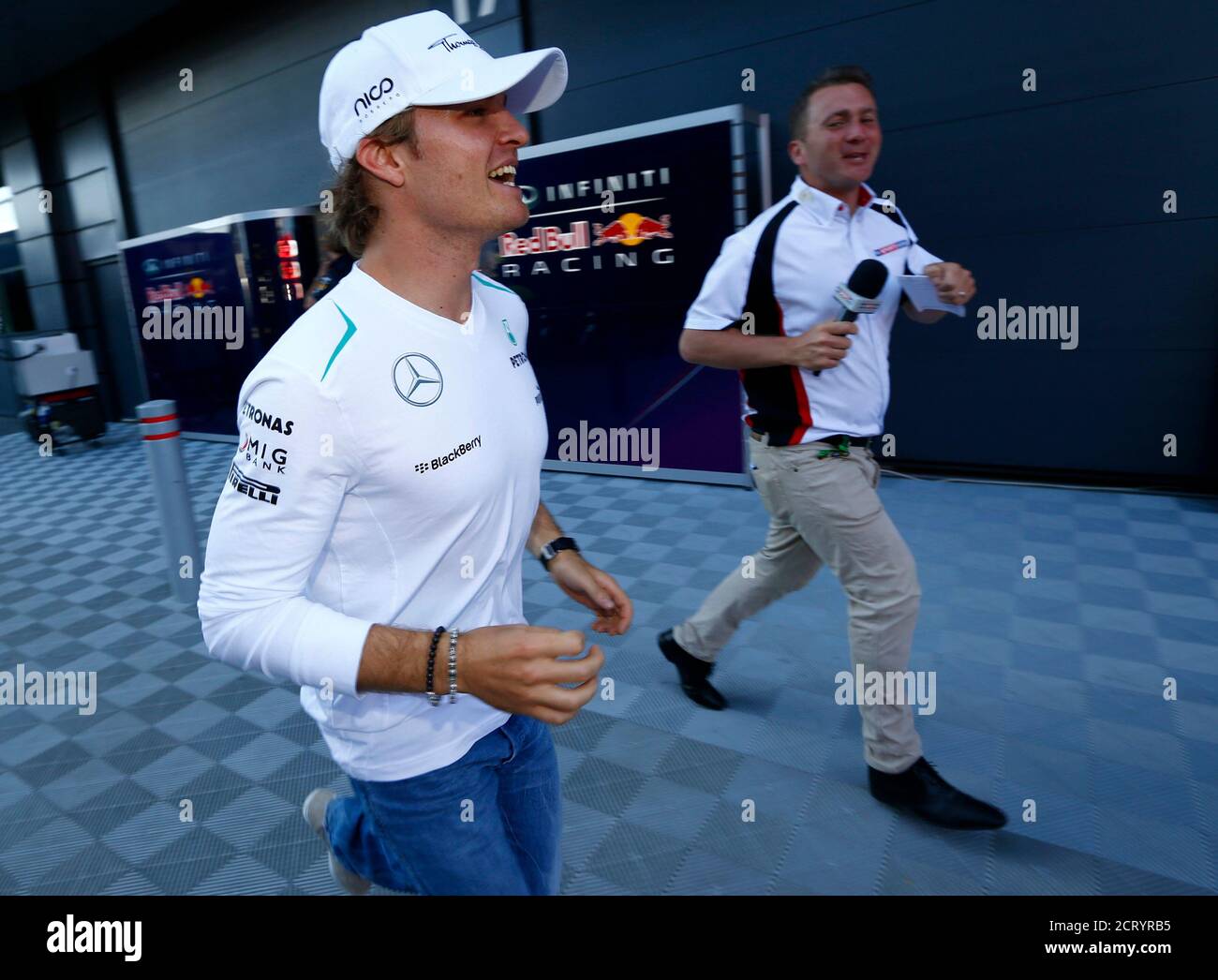 Mercedes Formula One driver Nico Rosberg of Germany runs from members of the media after appearing before race stewards after the British Grand Prix at the Silverstone Race circuit, central England, June 30, 2013. Rosberg was summoned to the stewards on Sunday for the Mercedes driver's apparent failure to slow for yellow warning flags during the race.  REUTERS/Darren Staples   (BRITAIN - Tags: SPORT MOTORSPORT F1) Stock Photo
