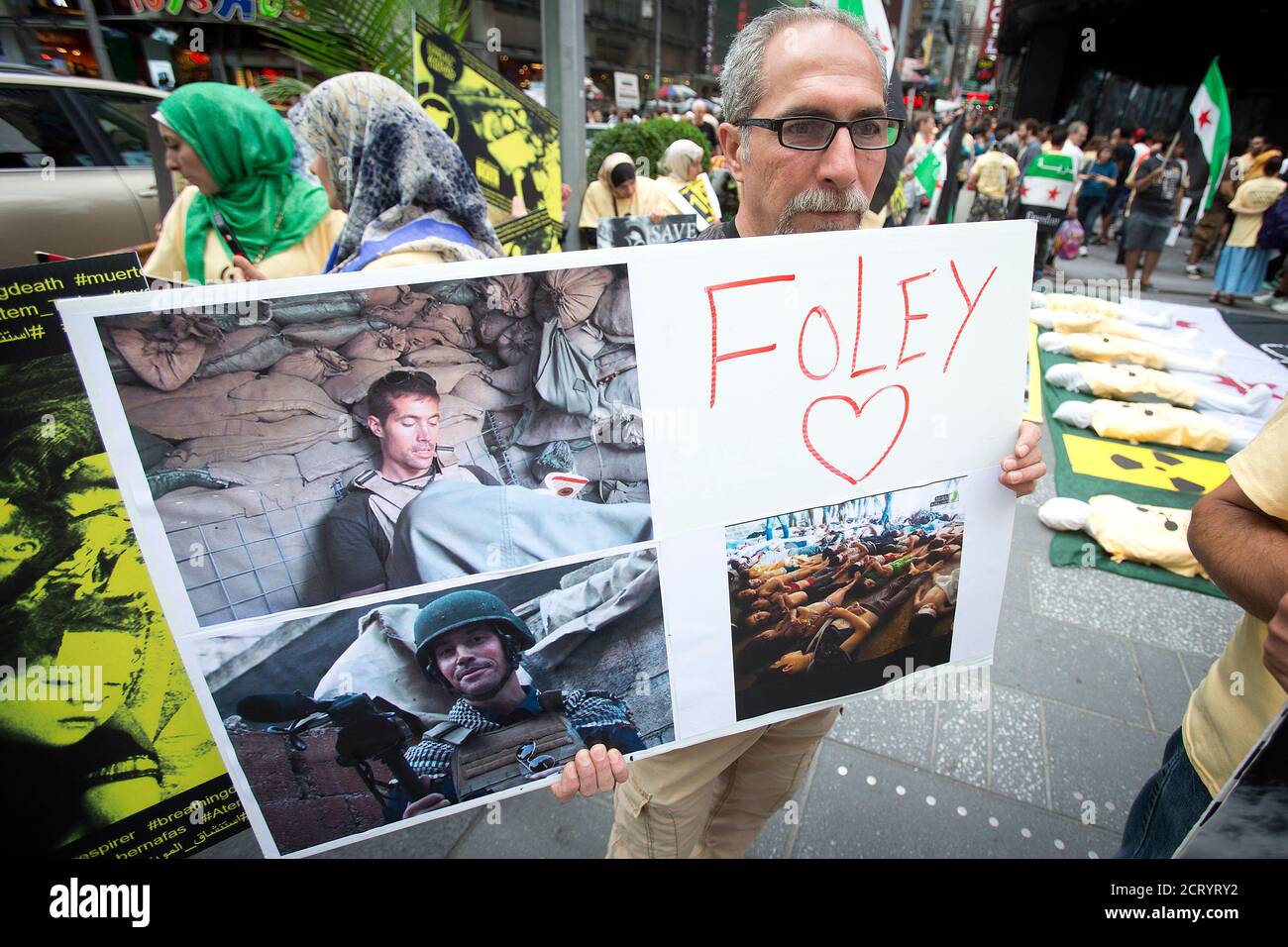 A man holds up a sign in memory of U.S. journalist James Foley during a protest against the Assad regime in Syria in Times Square in New York August 22, 2014. Foley, who was abducted in Syria in late 2012, was beheaded by a masked member of the Islamic State group in an act filmed in a video released on August 19 that also threatened a second American journalist, Steven Sotloff.   REUTERS/Carlo Allegri (UNITED STATES - Tags: SOCIETY CIVIL UNREST) Stock Photo