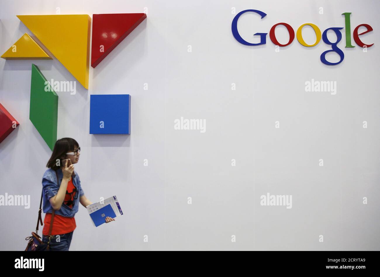 A woman walks past a logo of Google at the Global Mobile Internet Conference (GMIC) 2015 in Beijing, China, April 28, 2015. This logo has been updated and is no longer in use.  REUTERS/Kim Kyung-Hoon Stock Photo