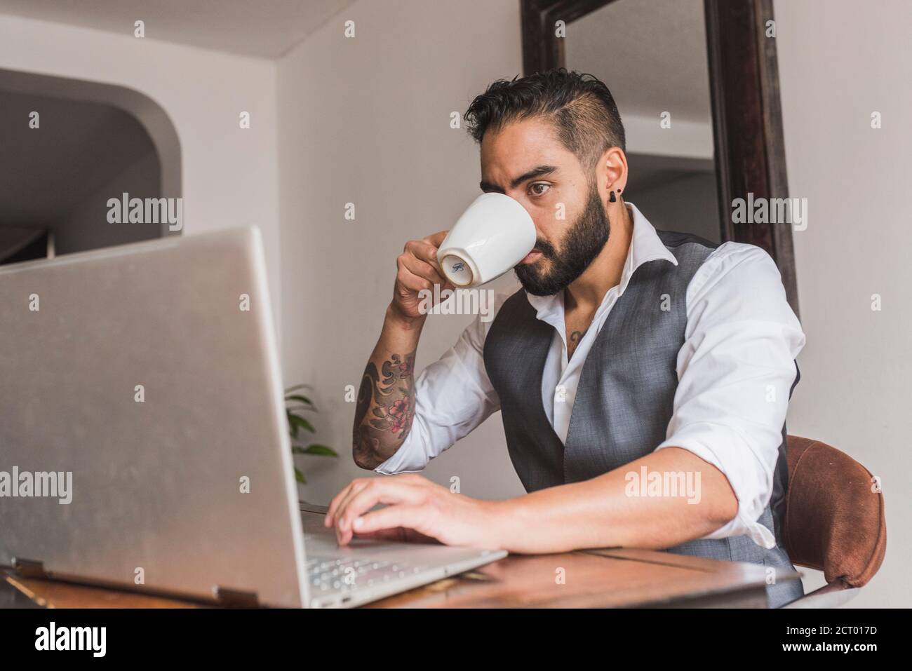 Handsome man dressed as executive  drinking coffee and working Stock Photo