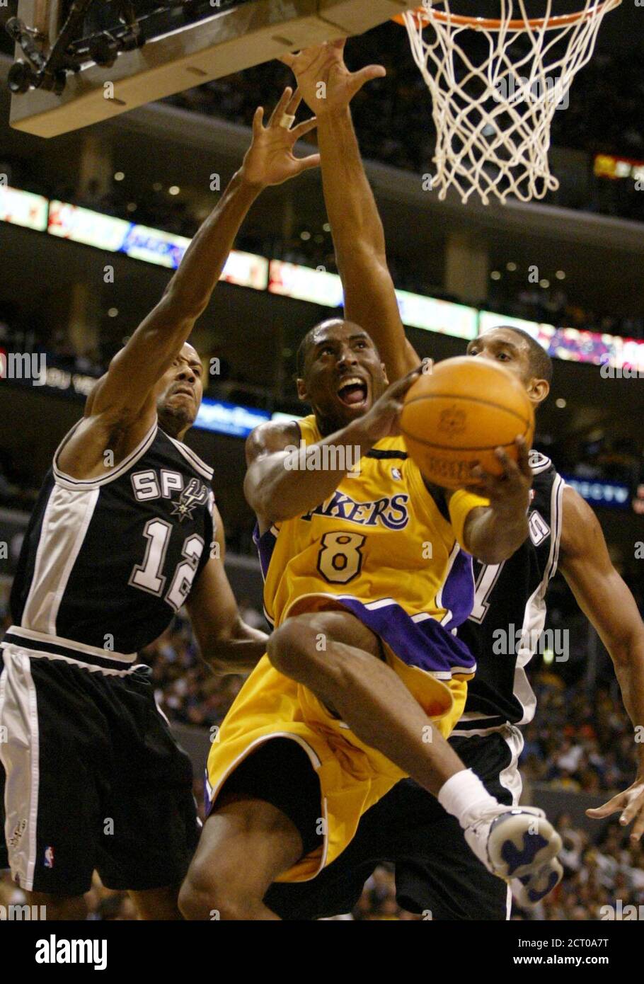 Los Angeles Lakers Kobe Bryant 8 Drives Against San Antonio Spurs Bruce Bowen L And Tim Duncan R During First Half Action Of Their Regular Season Opening Game At The Staples Center