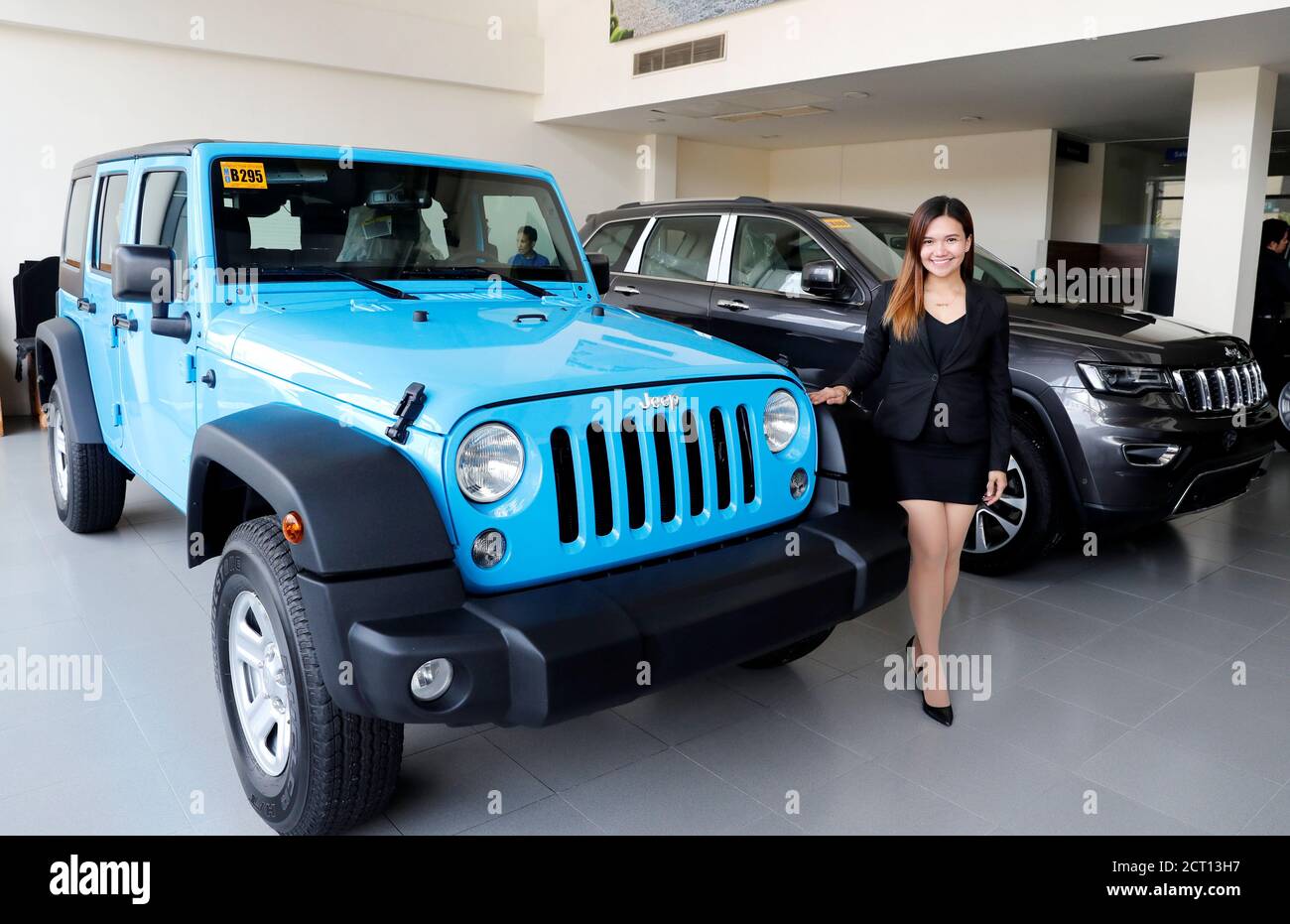 A sales worker poses between . made Jeep Wrangler and Cherokee SUV, at a local dealer of . made vehicles, Automotive Icon in Alabang, Metro Manila, Philippines August 15, 2018. REUTERS/Erik De A sales worker poses between . made Jeep Wrangler and Cherokee SUV, at a local dealer of . made vehicles, Automotive Icon in Alabang, Metro Manila, Philippines August 15, 2018. REUTERS/Erik De