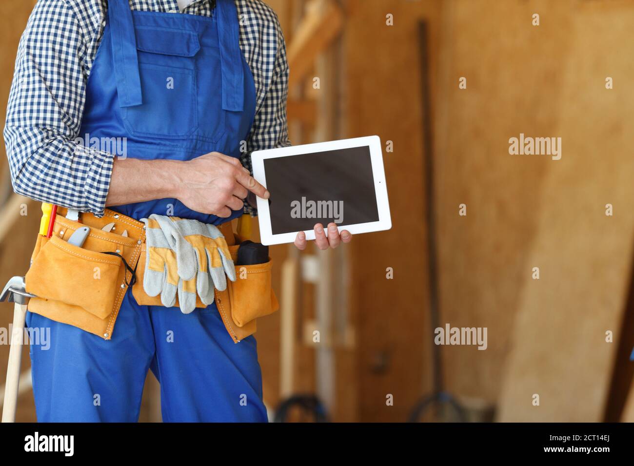 Construction worker at site pointing at blank digital tablet pc with copy space for text Stock Photo
