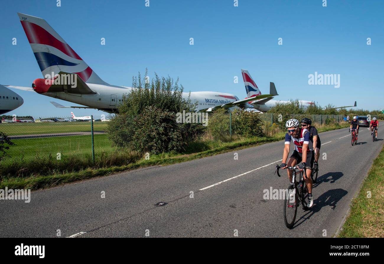 Kemble, Gloucestershire, England, UK. 2020. British Airways 747 aircraft lines up for disassembly at Cotswold Airport due to Covid epidemic. Cyclists Stock Photo