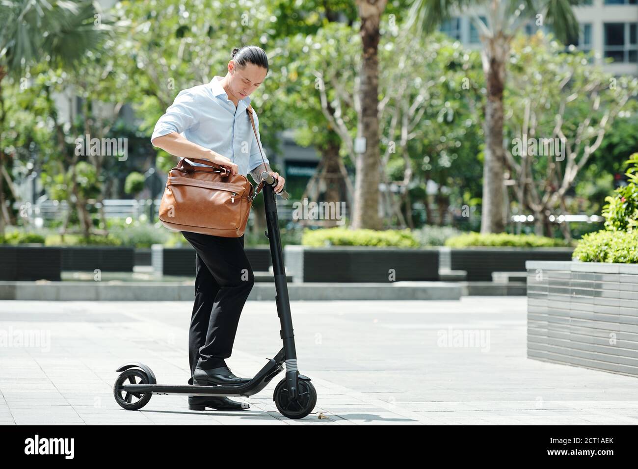 Businessman standing on scooter Stock Photo