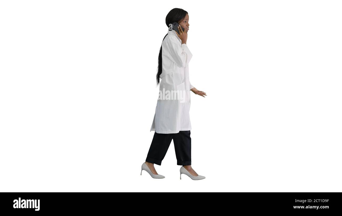 African american female doctor talking on the phone while walkin Stock Photo