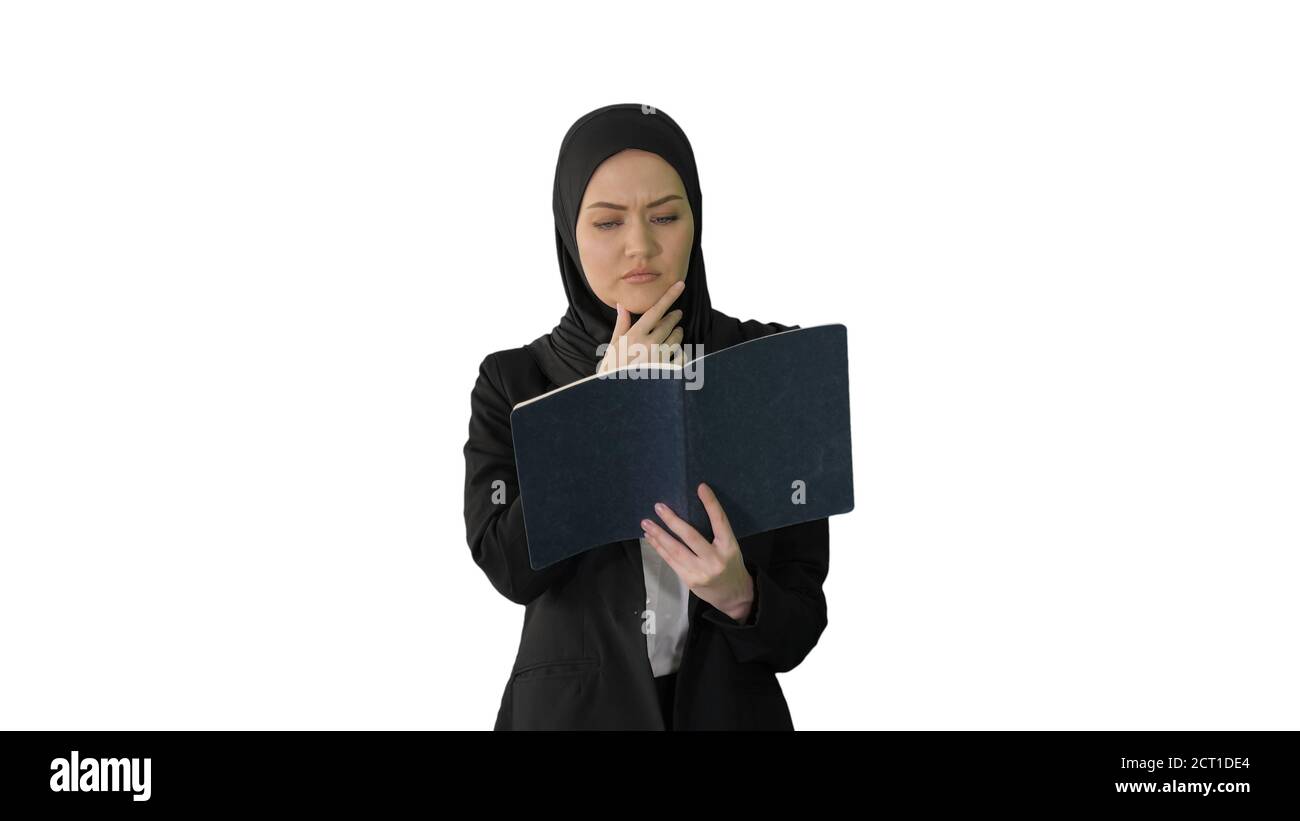 Muslim Businesswoman reading her business planner while walking Stock Photo