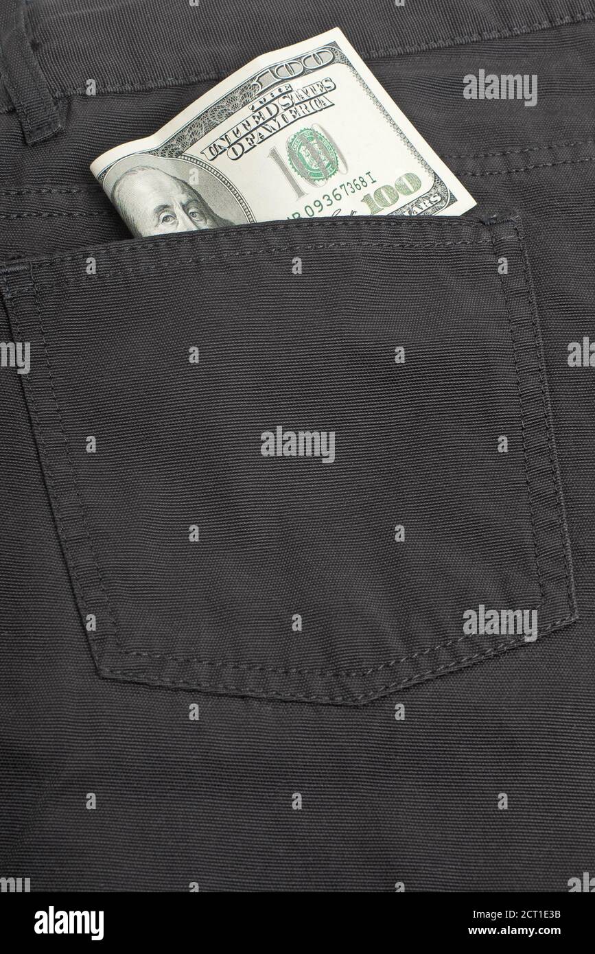 Closeup of back pocket of black jeans with one hundred dollar banknote inside Stock Photo