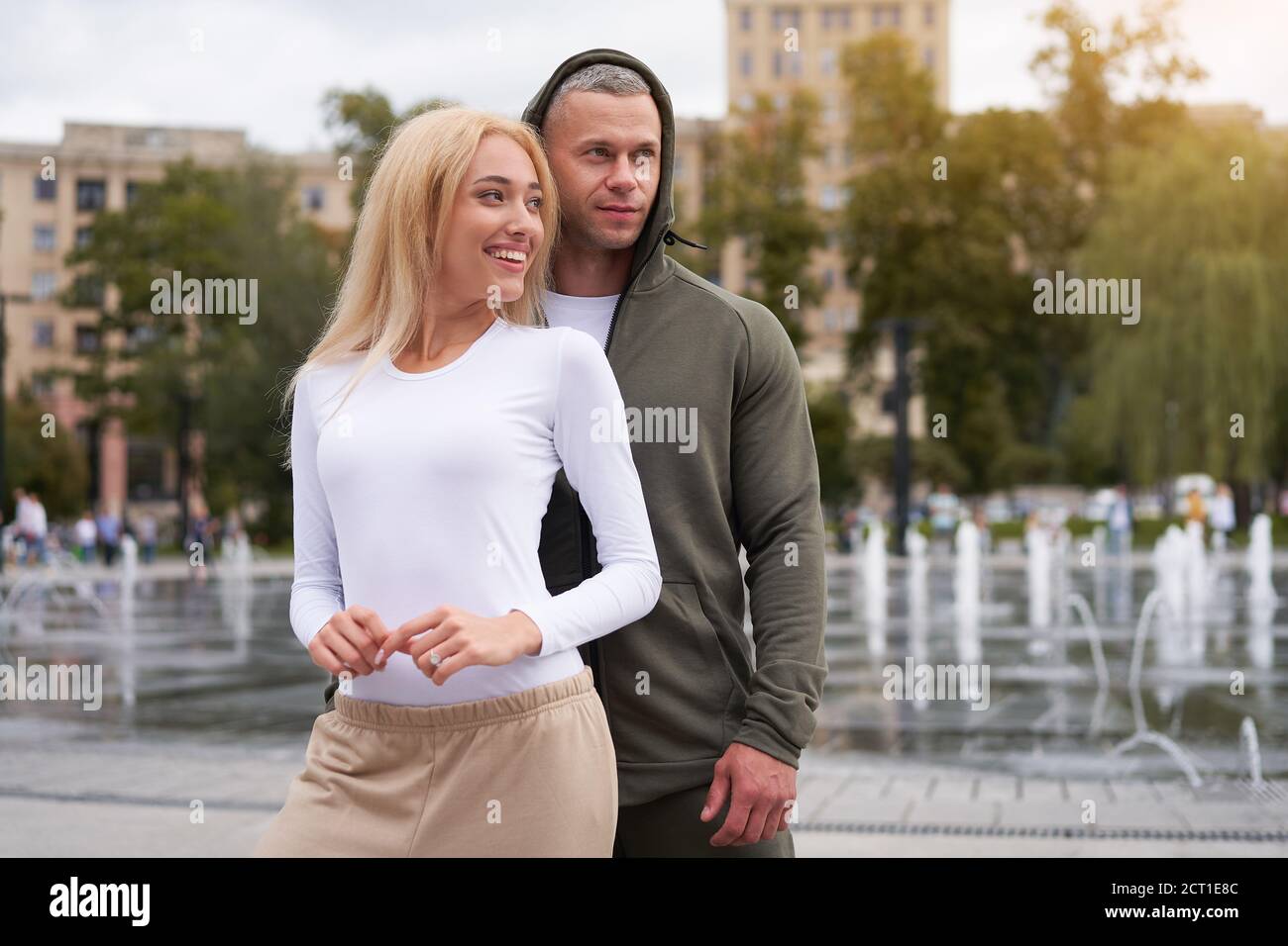 Couple in love walking outdoors park fountain Caucasian man woman walk outside after jogging dressed sport clothes  Healthy livestyle dress up the hoo Stock Photo