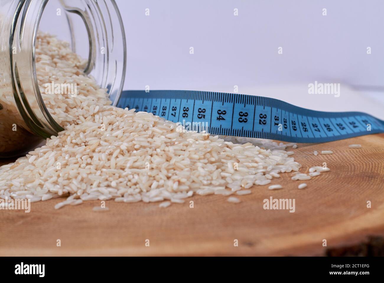 Pile of rice from a jar and measure tape. Stock Photo