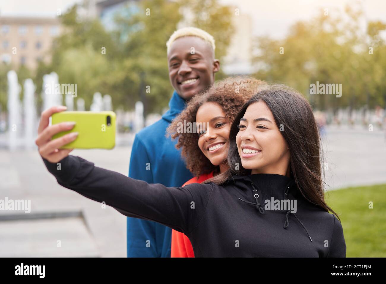 Multi ethnic friends outdoor taking a selfie on smartphone. Diverse ...