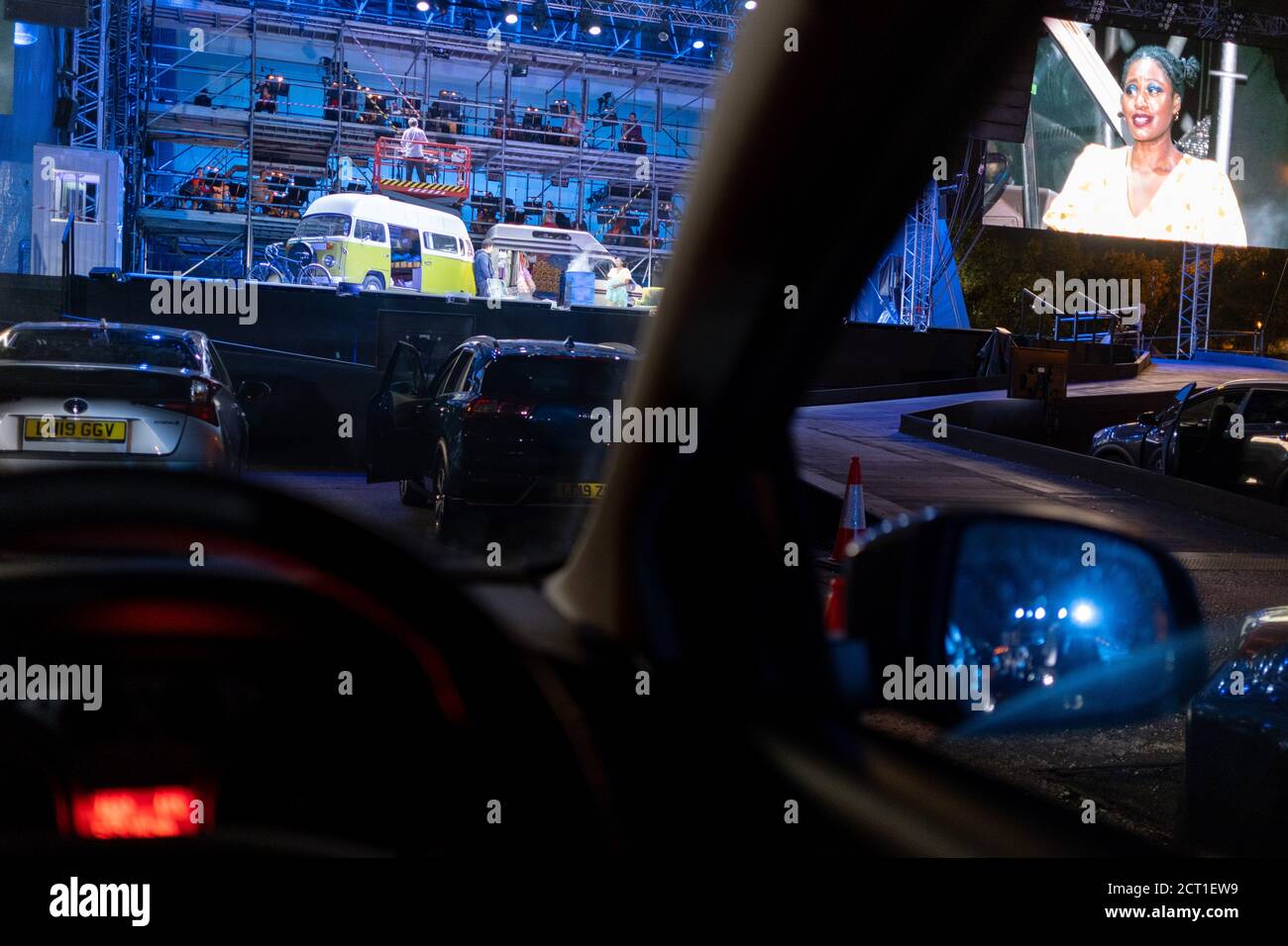Seen from the driver's seat, British Soprano Nardus Williams plays Mimi in Puccini's La bohème, performed by English National Opera (ENO) as a drive-in (ENO Drive and Live) at Alexandra Palace, on 18th September 2020, in London, England. This is ENO's first public performance since the closure of their West End Colisseum home venue, because of the Coronavirus pandemic lockdown in March. This is Europe's first live drive-in opera production that audiences can safely experience from their cars and ENO's first public performance since the closure of their West End Colisseum home venue, because of Stock Photo