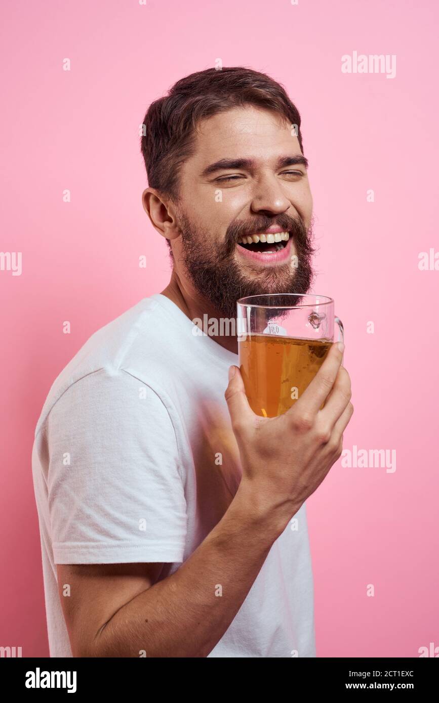 Bearded man with a mug of beer On a pink background fun emotions