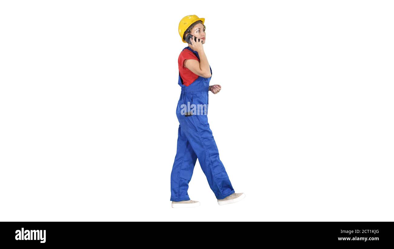 Young female architect consultant talking on phone while walking Stock Photo
