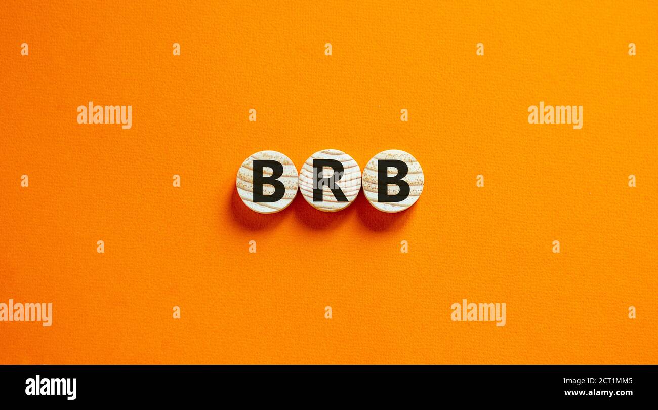Wide view image of BRB abbreviation spelled on wooden circles. Placed over beautiful orange background, copy space. Business concept. Stock Photo
