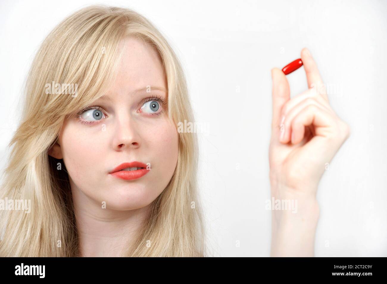 Young woman with pill tablet on white background. Health care concept Stock Photo