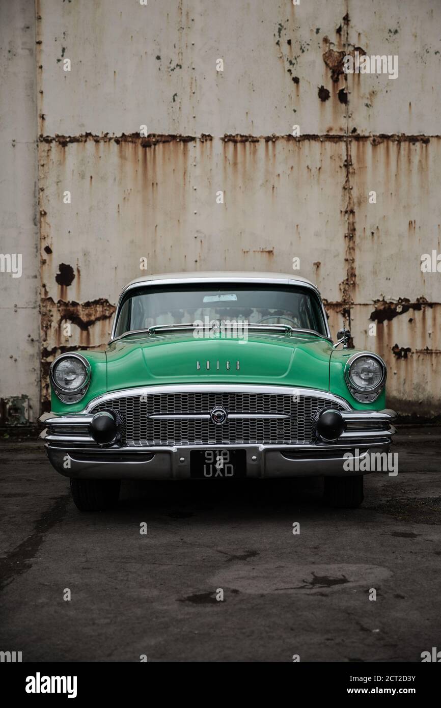 A Green 1955 Buick Century against a an old hanger Stock Photo