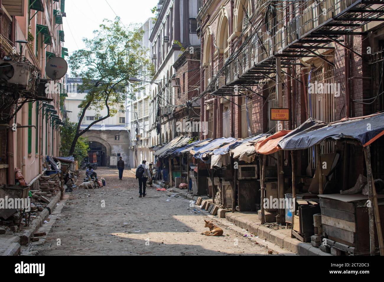 Kolkata, India - February 1, 2020: A few unidentified people in a local alleyway with closed market stalls with tarps on February 1, 2020 in Kolkata Stock Photo