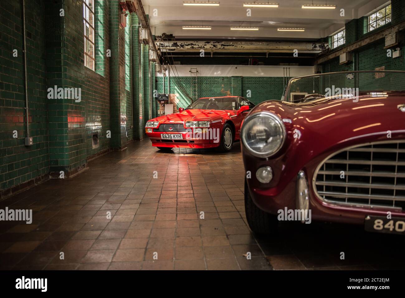 A 1985 Aston Martin V8 Zagato in red with an AC Ace Bristol in the foreground. Stock Photo