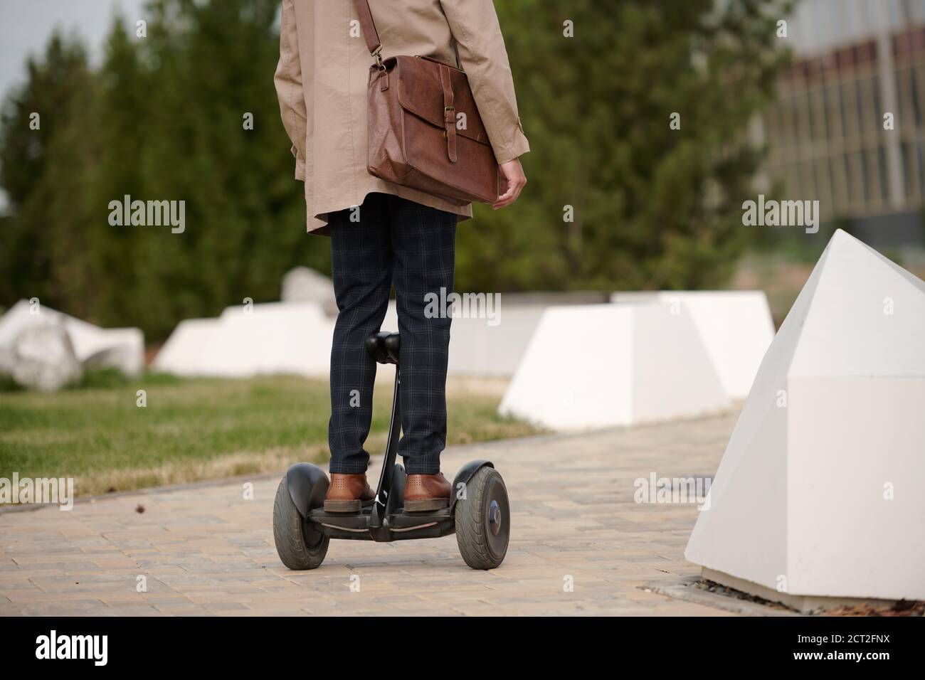 Rear view of contemporary businessman in smart casualwear riding gyroscope Stock Photo