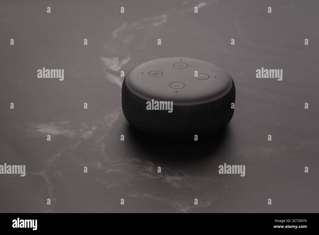 LONDON, UNITED KINGDOM - SEPTEMBER 20 2020: Close-up of an Amazon Echo Dot, the virtual assistant speaker, with a modern marble stone background. Stock Photo
