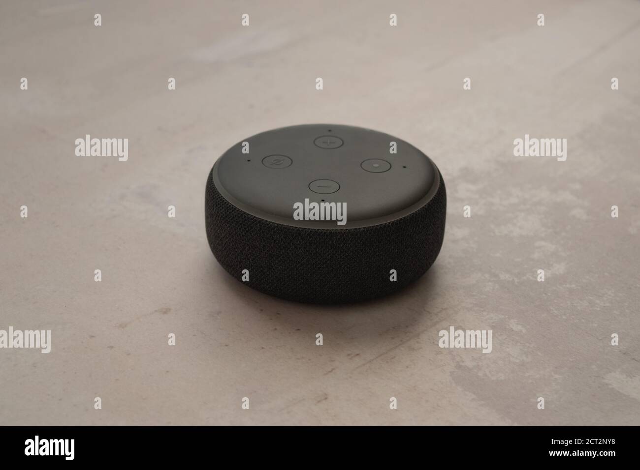 LONDON, UNITED KINGDOM - SEPTEMBER 20 2020: Close-up of an Amazon Echo Dot, the virtual assistant speaker, with a modern concrete stone background. Stock Photo