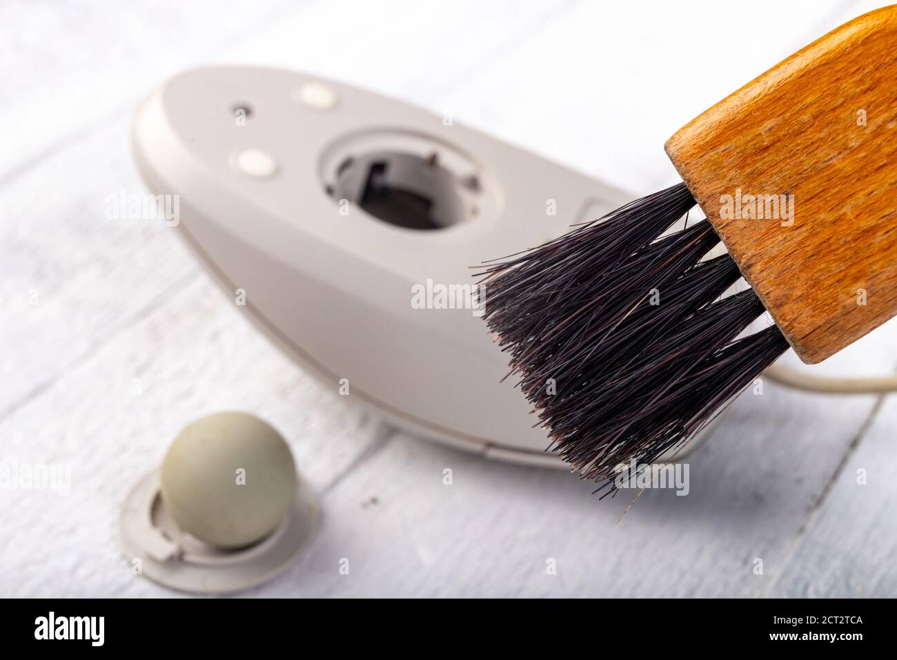 Cleaning with a brush of an old mouse. Office accessories for work. Light background. Stock Photo