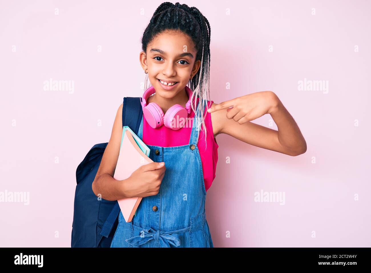 Young african american girl child with braids holding student backpack