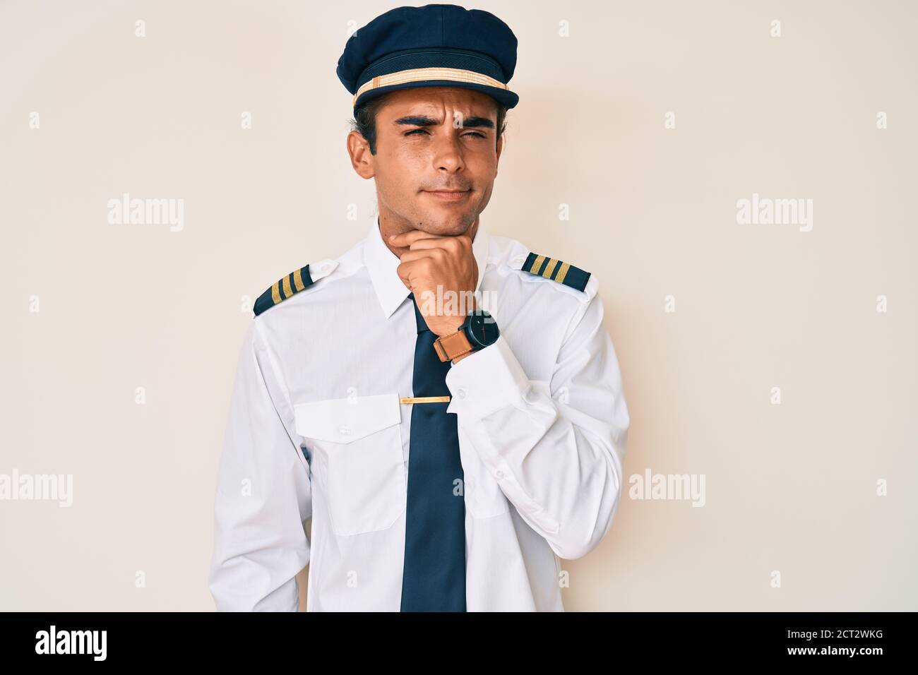 Young hispanic man wearing airplane pilot uniform touching painful neck, sore throat for flu