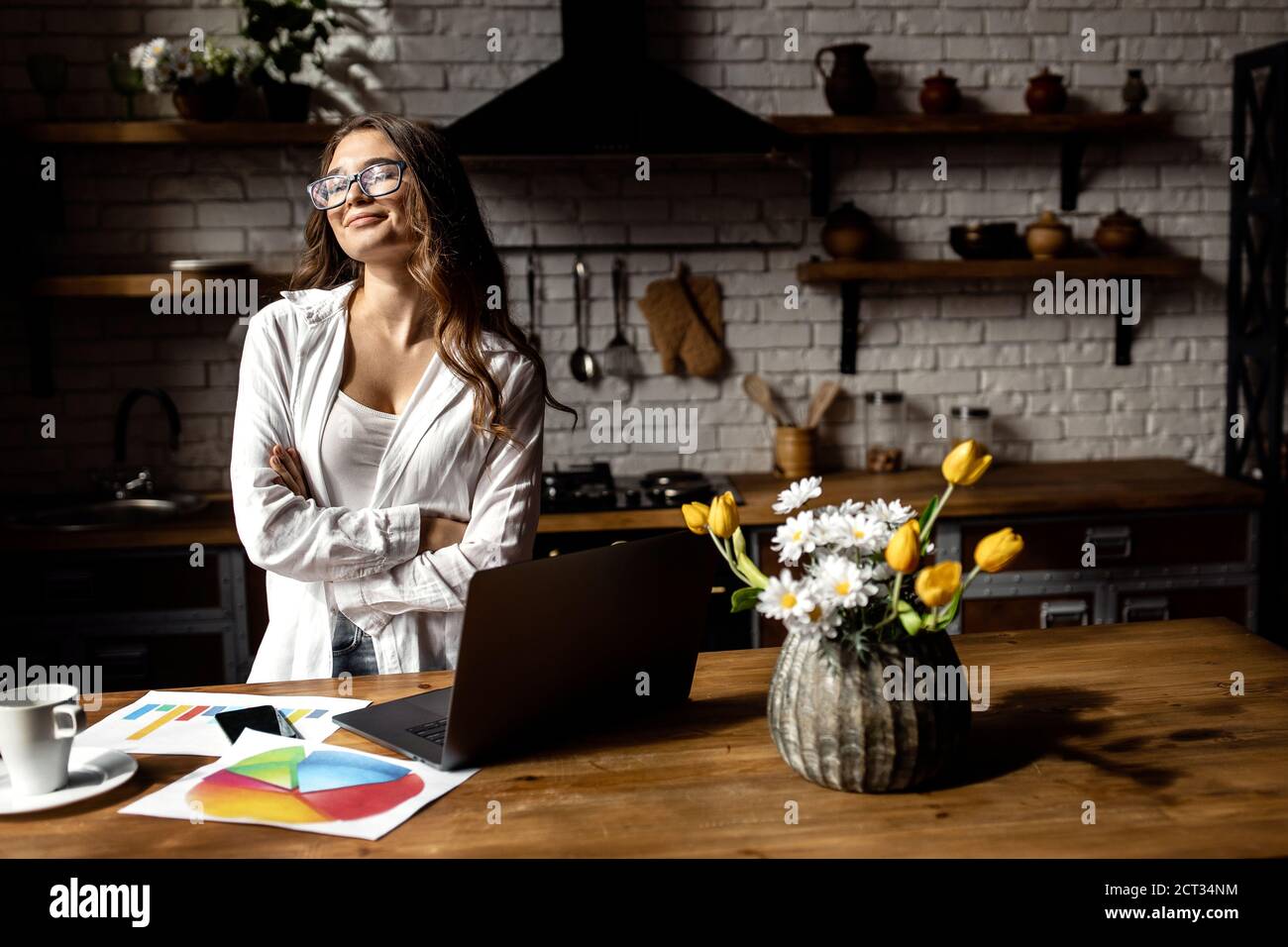 Happy business lady working from home . Beautiful lady working with documents at the kitchen  Stock Photo