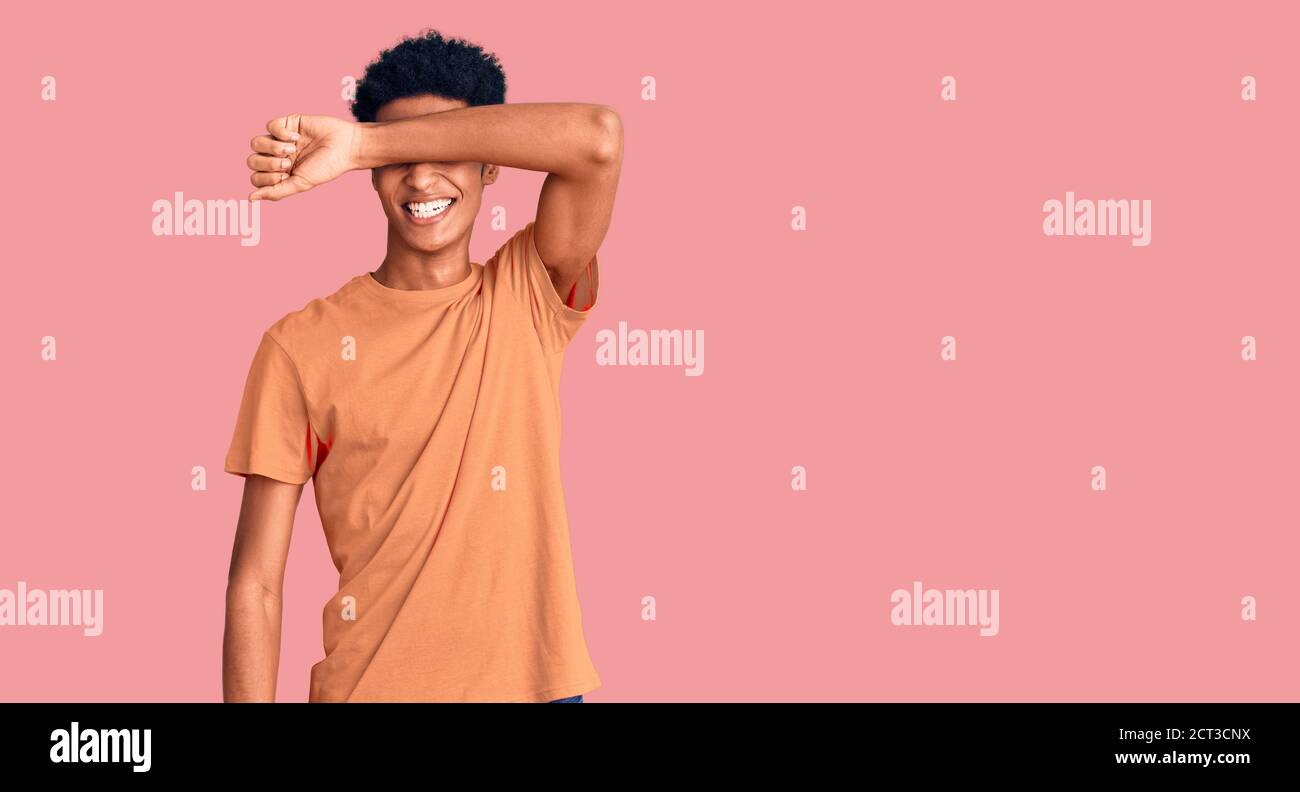 Young african american man wearing casual clothes covering eyes with ...