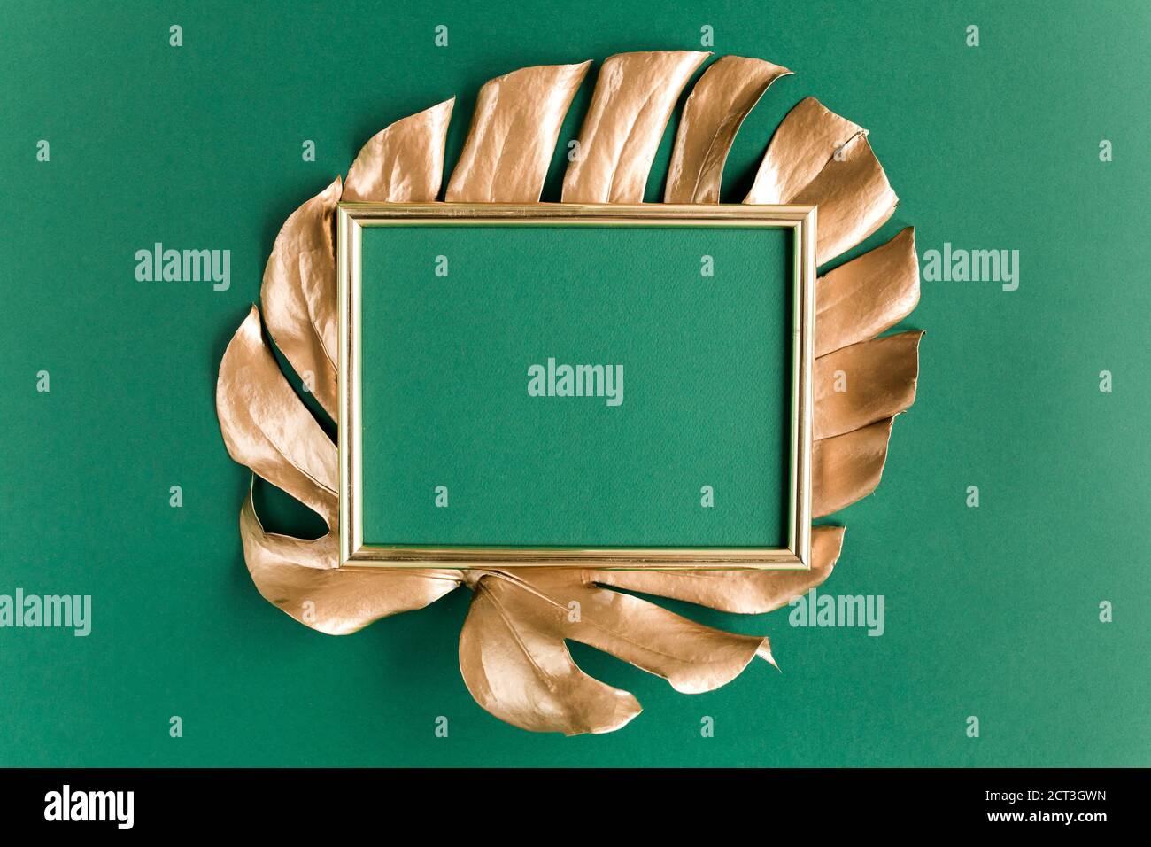 Gold tropical palm leaves Monstera and photo frame on green background ...