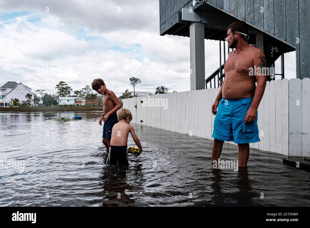 Gulf Shores, ALABAMA, USA. 17th Sep, 2019. (left to right) Luke Ross, 4, and his brother Cade, 9, walk through flood waters from Hurricane Sally with their father Joseph as he inspects his property in Gulf Shores, Alabama USA on September 17, 2020. Hurricane Sally made as a Category 2 Hurricane. Hurricane Sally made as a Category 2 Hurricane bringing wind damage and flooding to parts of the Gulf Coast. Credit: Dan Anderson/ZUMA Wire/Alamy Live News Stock Photo